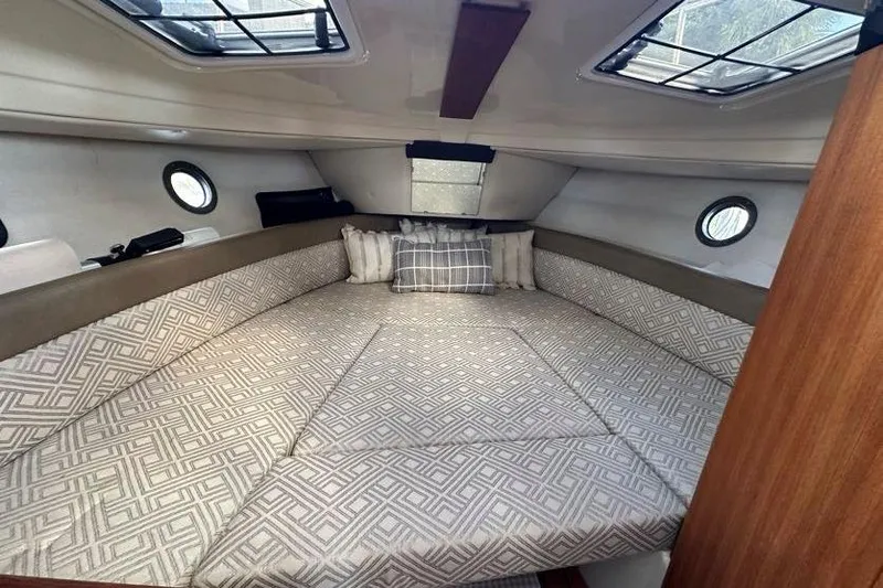 Slide: The Image of 2020 Ranger Tugs R-23 cabin interior with patterned bedding and porthole windows. - 24