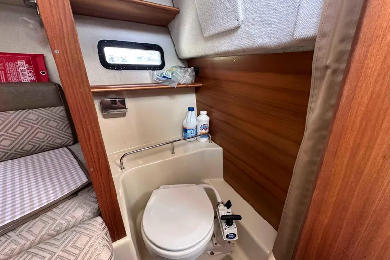 Slide: The Image of 2020 Ranger Tugs R-23 boat interior with compact bathroom and wooden accents. - 25
