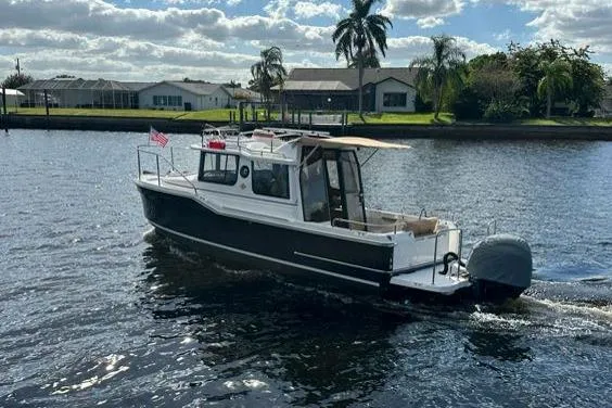 Slide: The Image of 2020 Ranger Tugs R-23 boat cruising on a sunny day in a residential canal. - 3