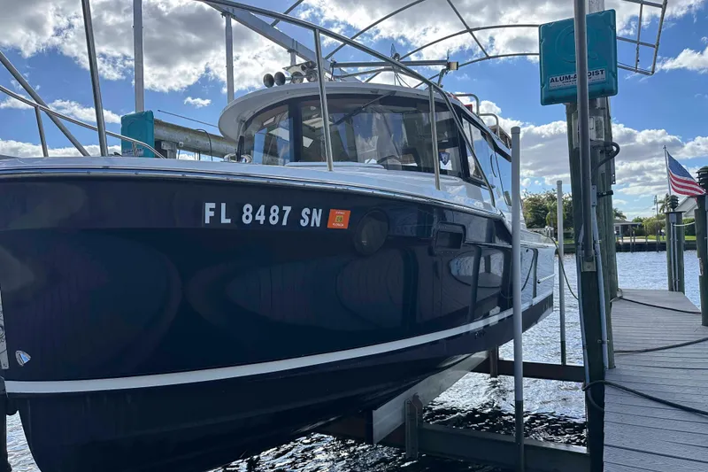 Slide: The Image of 2020 Ranger Tugs R-23 boat docked, displaying Florida registration, under a partly cloudy sky. - 4