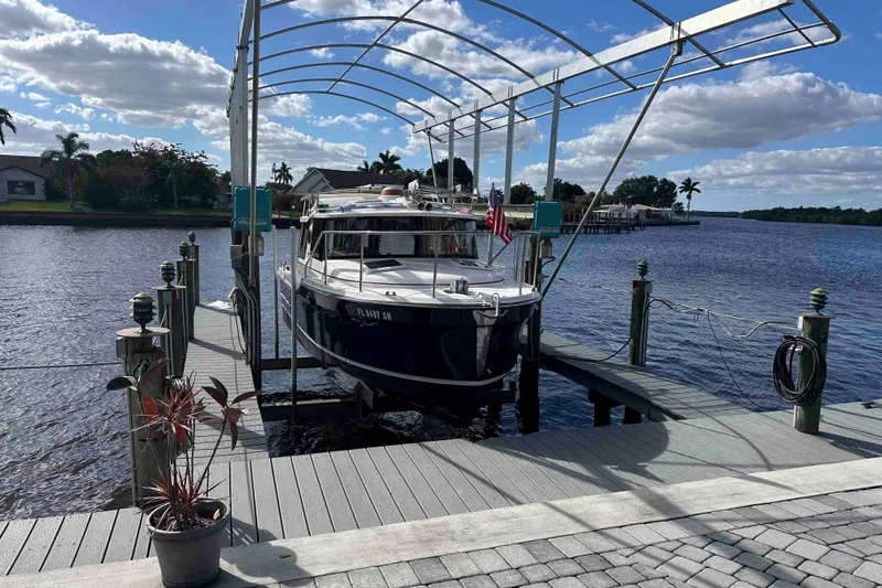 Slide: The Image of 2020 Ranger Tugs R-23 boat docked on a scenic waterfront with clear skies. - 6