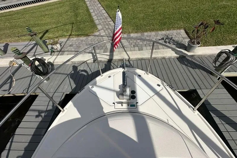 Slide: The Image of Bow view of 2020 Ranger Tugs R-23 boat docked, featuring American flag and deck details. - 8