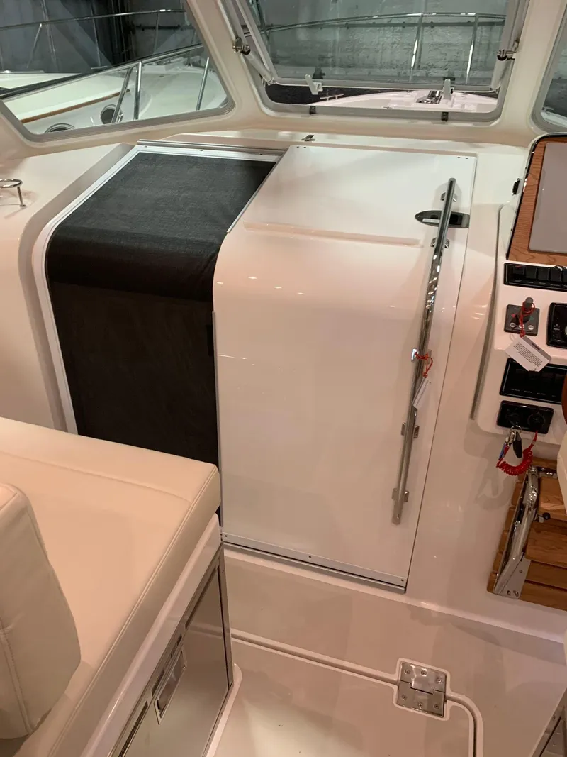 Slide: The Image of 2027 Back Cove 34O Hardtop Express interior helm station with modern controls. - 11