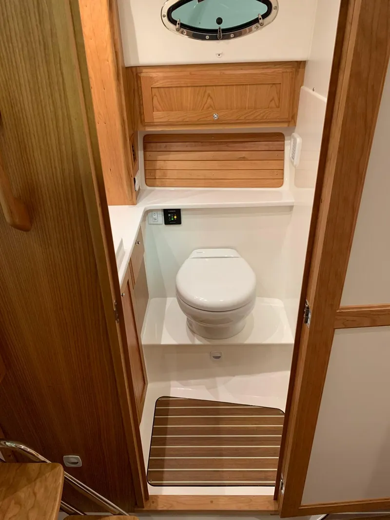 Slide: The Image of 2027 Back Cove 34O Hardtop Express boat bathroom with wooden cabinetry and modern fixtures. - 14
