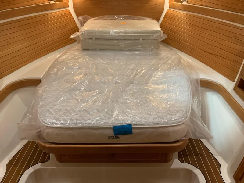 Slide: The Image of 2027 Back Cove 34O Hardtop Express cabin with a neatly wrapped mattress. - 15