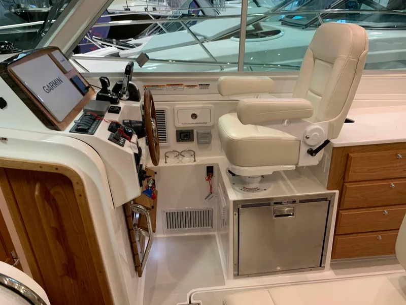 Slide: The Image of 2027 Back Cove 34O Hardtop Express helm with Garmin navigation, luxurious seating, and wooden accents. - 8