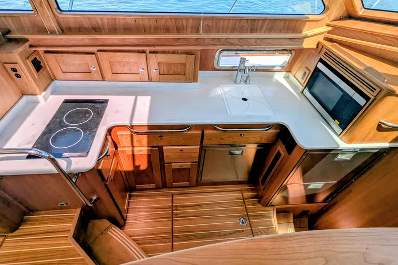 Slide: The Image of Modern kitchen interior of 2026 Sabre 45 Salon Express yacht with wood cabinetry and appliances. - 18