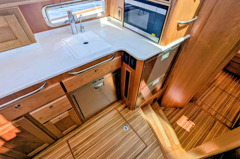 Slide: The Image of Modern kitchen interior of 2026 Sabre 45 Salon Express yacht with wood cabinetry and appliances. - 19