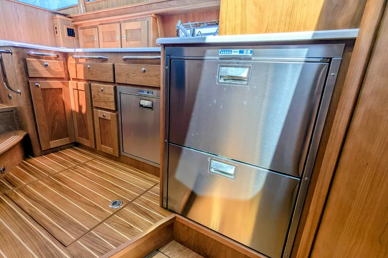 Slide: The Image of 2026 Sabre 45 Salon Express kitchen with stainless steel appliances and wooden cabinetry. - 21