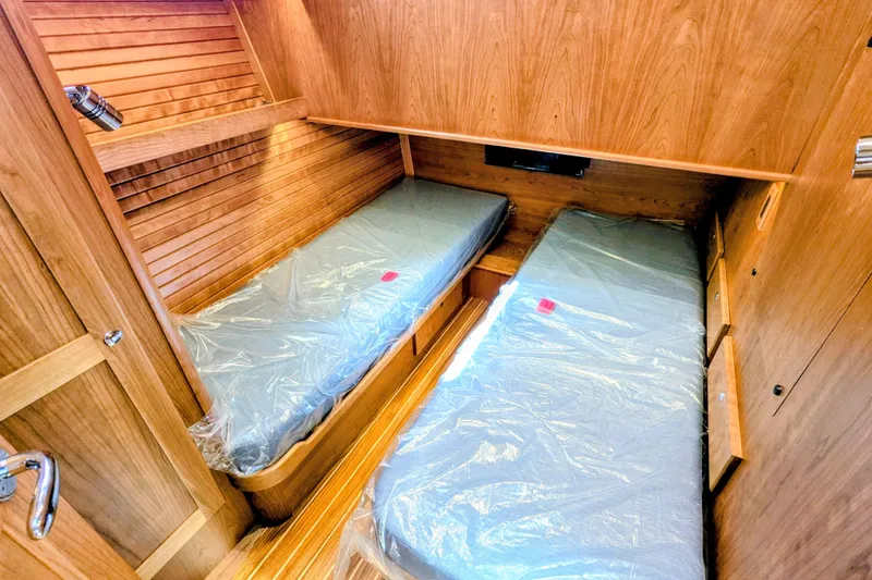 Slide: The Image of 2026 Sabre 45 Salon Express cabin with twin beds and wooden interior. - 24