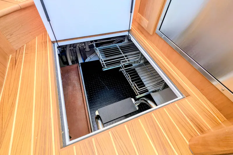 Slide: The Image of Engine compartment of 2026 Sabre 45 Salon Express with wooden flooring and storage racks. - 28