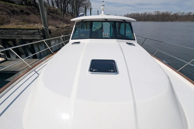 Slide: The Image of 2026 Sabre 45 Salon Express yacht docked by a serene riverbank. - 35