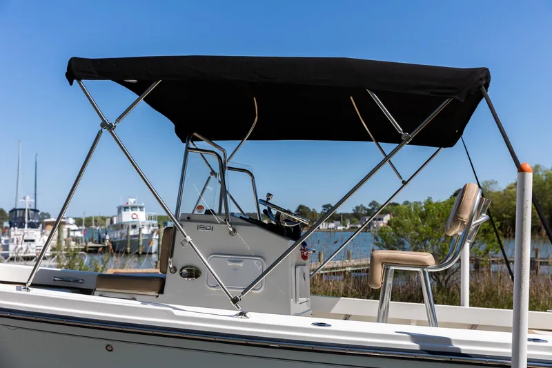 Slide: The Image of 2017 Parker 1801 Center Console boat with black canopy at the harbor. - 18