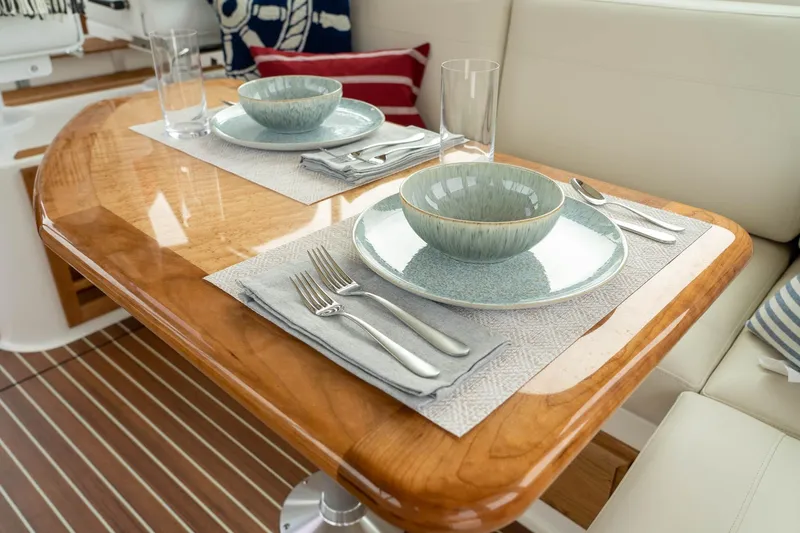 Slide: The Image of Elegant dining setup on 2027 Back Cove 372 yacht with polished wood table. - 10