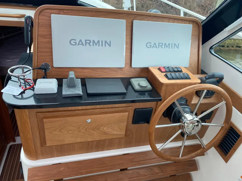 Slide: The Image of 2025 Back Cove 37 Hardtop Express helm with dual Garmin displays and wooden steering wheel. - 15