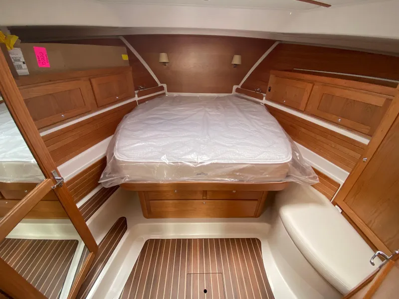 Slide: The Image of 2025 Back Cove 37 Hardtop Express cabin with wooden interior and cozy bed. - 17