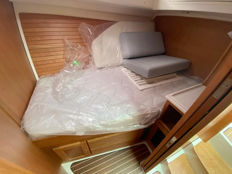 Slide: The Image of 2025 Back Cove 37 Hardtop Express cabin with wooden interior and cushioned bed. - 18