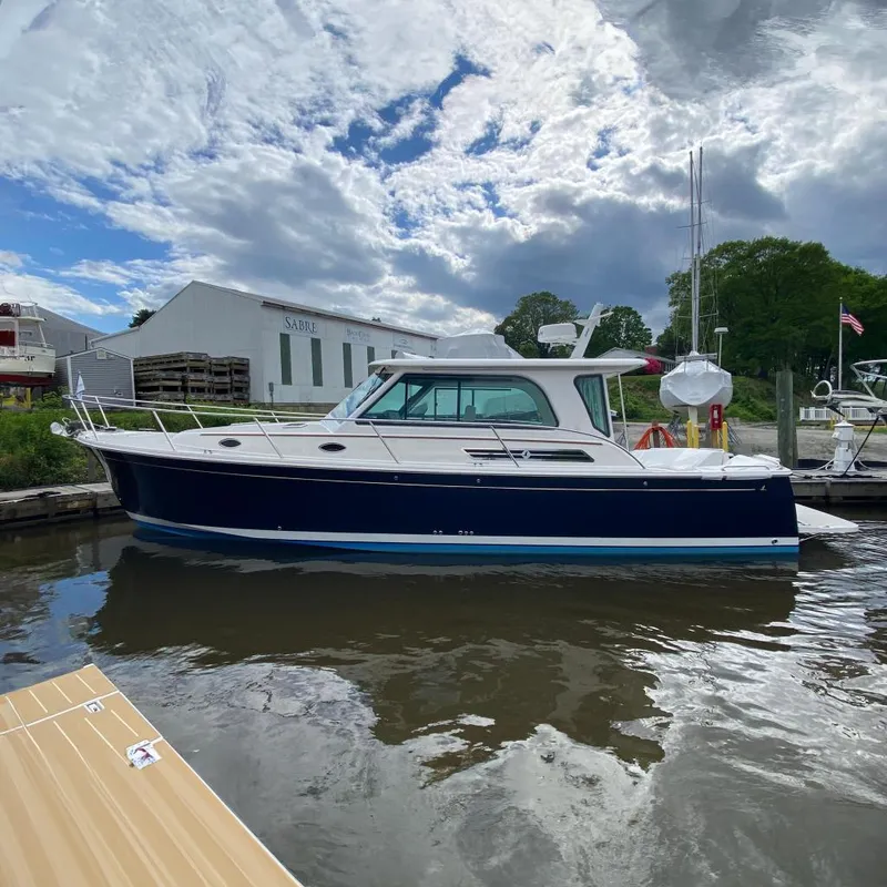 Slide: The Image of 2025 Back Cove 37 Hardtop Express boat docked under cloudy sky. - 2