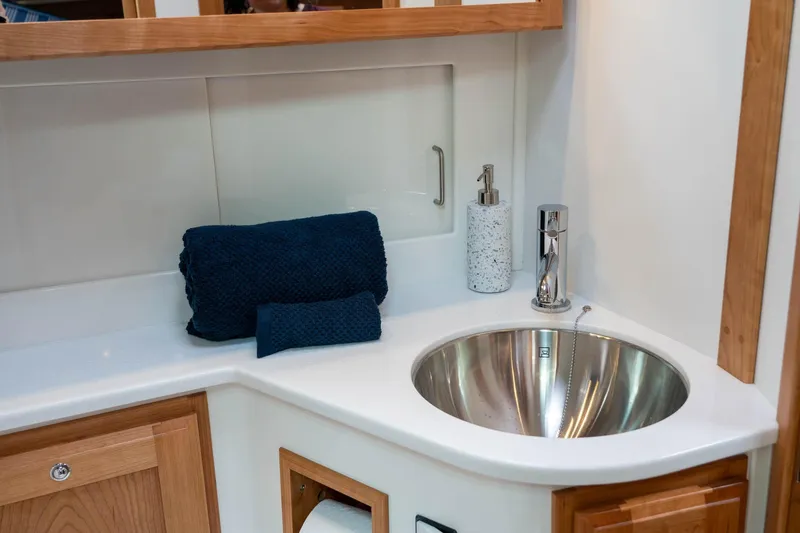 Slide: The Image of Luxurious bathroom sink area in 2027 Back Cove 372 yacht, featuring modern fixtures and navy towels. - 21