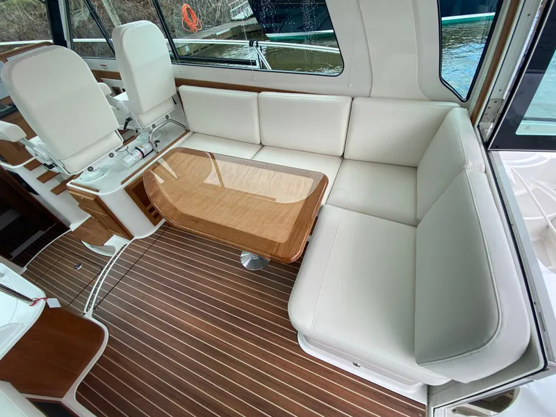 Slide: The Image of 2025 Back Cove 37 Hardtop Express interior with white seating and wooden table. - 8