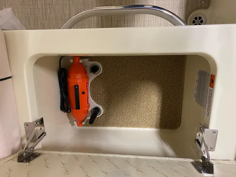 Slide: The Image of Storage compartment in 2025 Chris-Craft Launch 28 GT boat with orange device inside. - 12