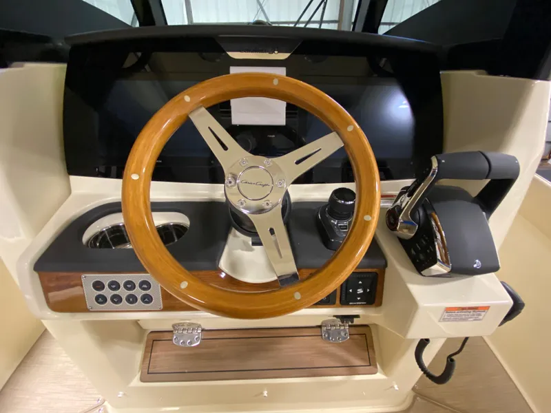 Slide: The Image of 2026 Chris-Craft Catalina 28 helm with wooden steering wheel and modern controls. - 12