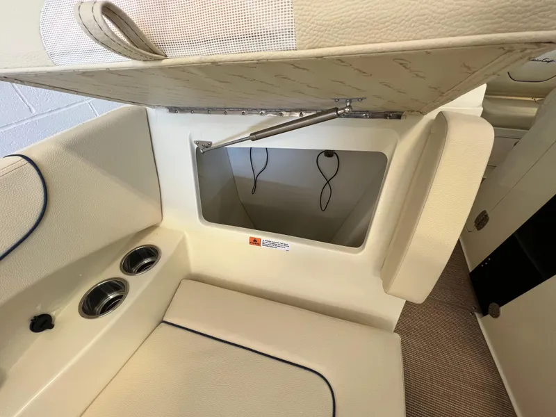Slide: The Image of 2024 Chris-Craft Calypso 28 storage compartment with open lid and cup holders. - 12