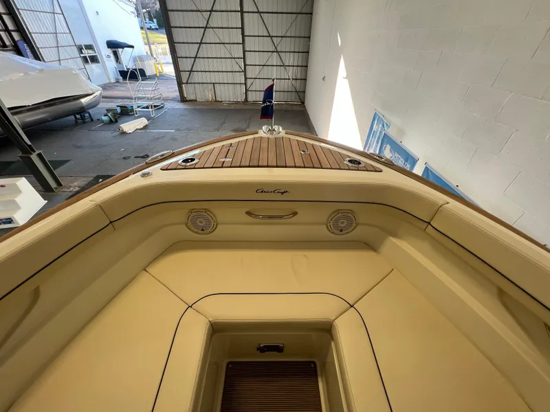 Slide: The Image of 2024 Chris-Craft Calypso 28 boat interior with beige seating and wooden deck. - 13