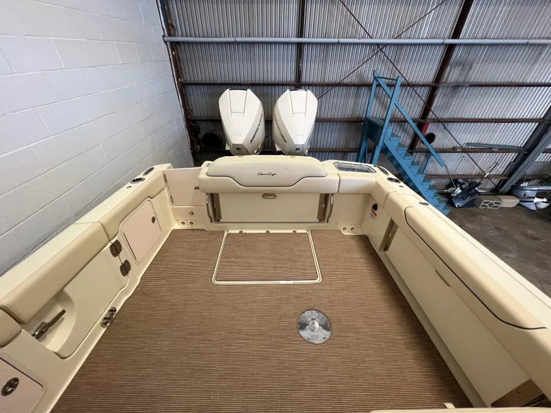 Slide: The Image of 2024 Chris-Craft Calypso 28 boat interior with twin outboard engines in a warehouse. - 19