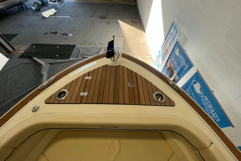 Slide: The Image of 2024 Chris-Craft Calypso 28 boat bow with teak decking and beige seating. - 34