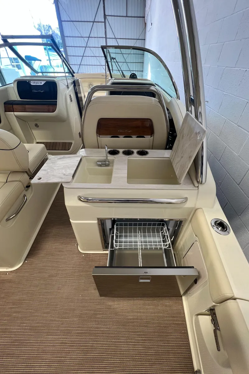Slide: The Image of 2024 Chris-Craft Calypso 28 boat interior with kitchenette and seating area. - 38