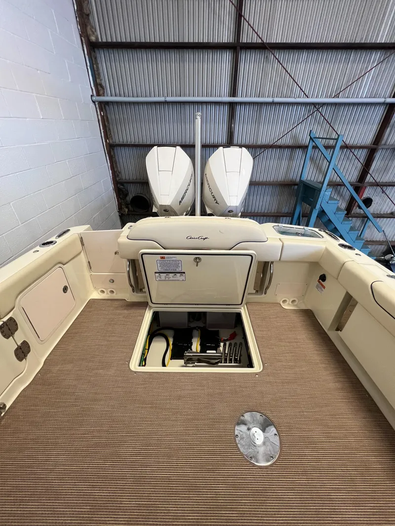 Slide: The Image of 2024 Chris-Craft Calypso 28 boat interior with twin engines in a warehouse. - 40