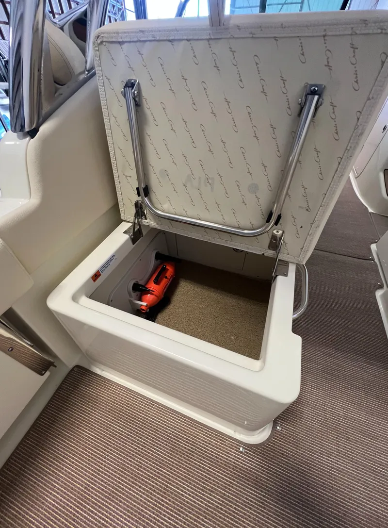 Slide: The Image of 2024 Chris-Craft Calypso 28 storage compartment with tool inside. - 43