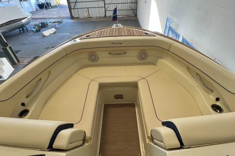 Slide: The Image of 2024 Chris-Craft Calypso 28 boat interior with beige seating and wooden deck. - 50