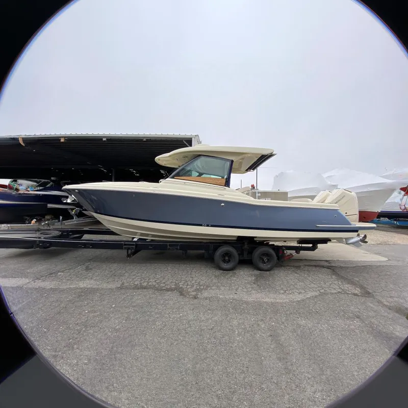 The Image of 2024 Chris-Craft Calypso 32 boat on a trailer in a marina. - 0