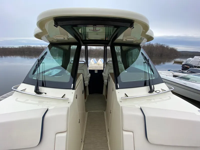 Slide: The Image of 2024 Chris-Craft Calypso 32 boat docked, showcasing its sleek design and spacious interior. - 19
