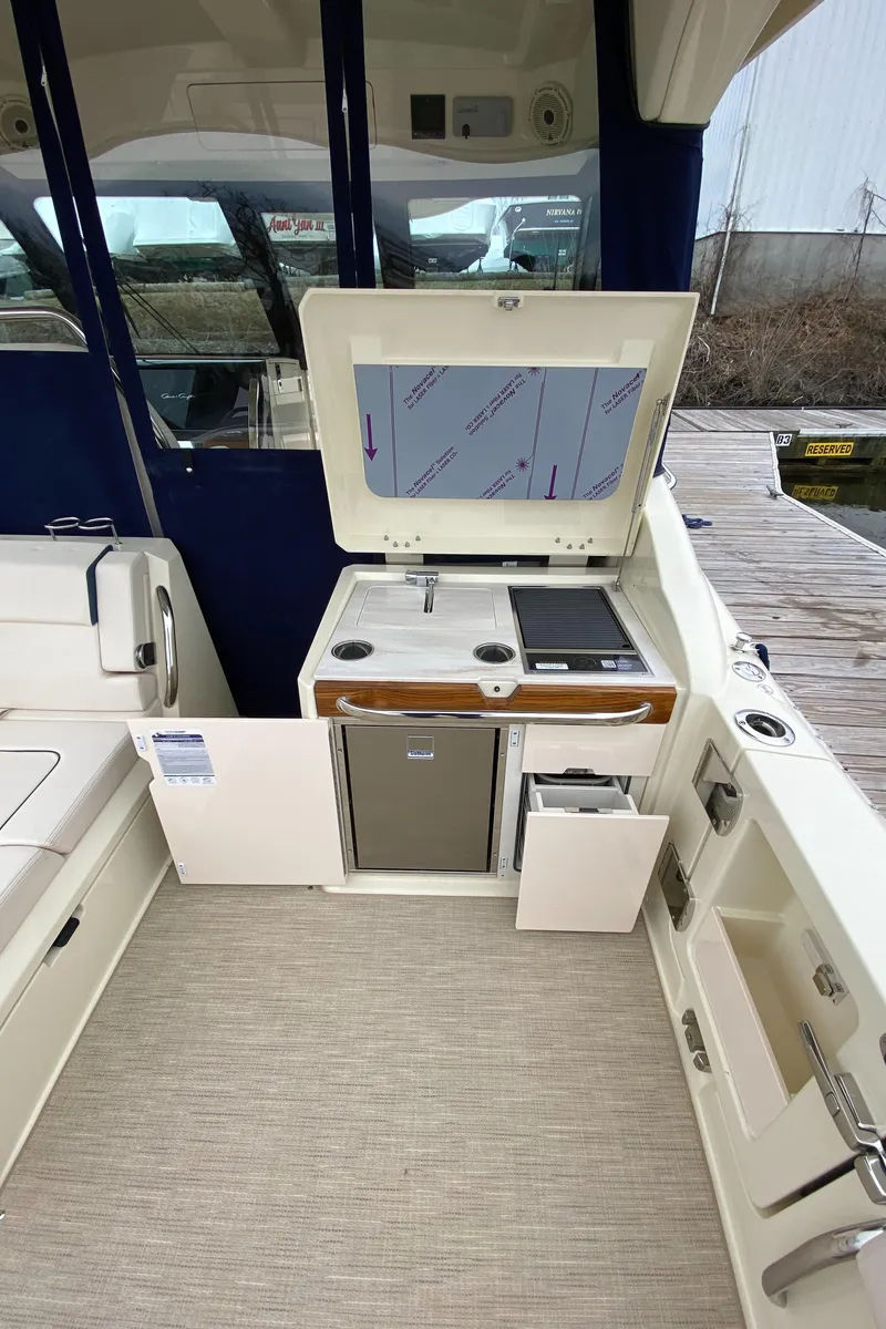 Slide: The Image of 2024 Chris-Craft Calypso 32 boat galley with stove, sink, and refrigerator. - 7