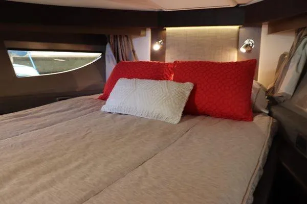 Slide: The Image of Interior cabin view of 2016 Sea Ray Sundancer 400 yacht, featuring wooden door and bed. - 16