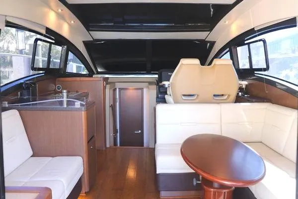 Slide: The Image of 2016 Sea Ray Sundancer 400 cabin with cozy bed, red pillows, and window curtains. - 37