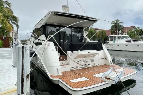 Slide: The Image of 2016 Sea Ray Sundancer 400 yacht docked, covered with black canvas, surrounded by palm trees. - 41