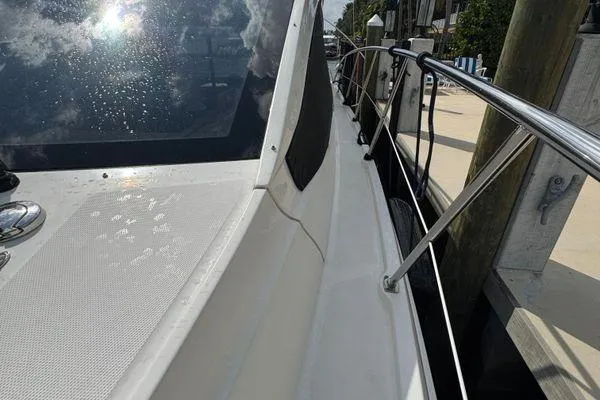 Slide: The Image of 2016 Sea Ray Sundancer 400 yacht docked in a scenic waterfront area. - 45