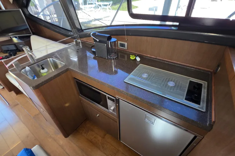 Slide: The Image of 2016 Sea Ray Sundancer 400 yacht kitchen with sink, stove, and appliances. - 57