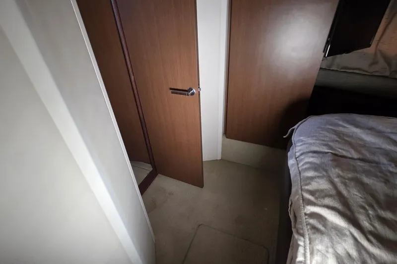 Slide: The Image of Interior of 2016 Sea Ray Sundancer 400 yacht, featuring a wooden door and cozy bedroom. - 59