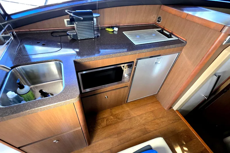 Slide: The Image of Compact kitchen area in a 2016 Sea Ray Sundancer 400 yacht with sink, microwave, and mini-fridge. - 62