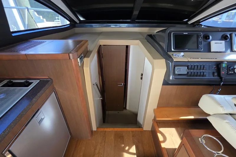 Slide: The Image of Interior view of 2016 Sea Ray Sundancer 400 yacht, featuring helm and cabin entrance. - 63
