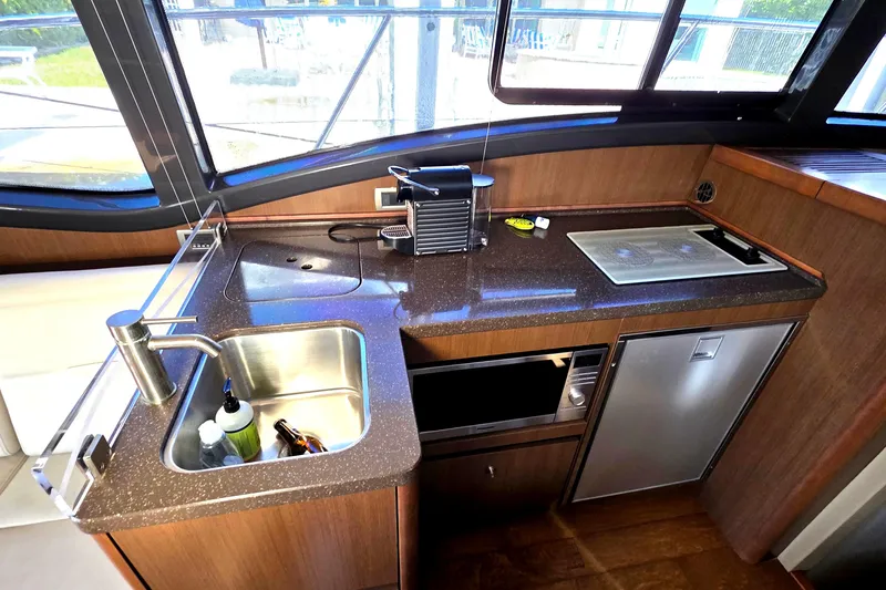 Slide: The Image of 2016 Sea Ray Sundancer 400 yacht kitchen with sink, stove, and appliances. - 68