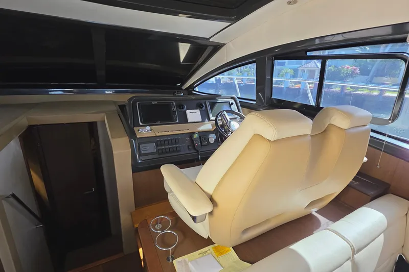 Slide: The Image of 2016 Sea Ray Sundancer 400 helm with beige seating and modern controls. - 69