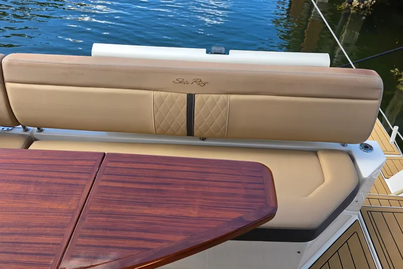 Slide: The Image of 2016 Sea Ray Sundancer 400 boat interior with tan seating and wooden table. - 77