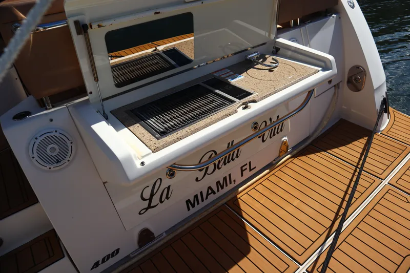 Slide: The Image of 2016 Sea Ray Sundancer 400 yacht with outdoor grill, named "La Bella Vita," docked in Miami. - 84