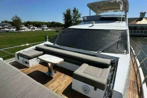 Slide: The Image of 2020 Azimut 66 yacht with outdoor seating on deck, docked near greenery. - 10